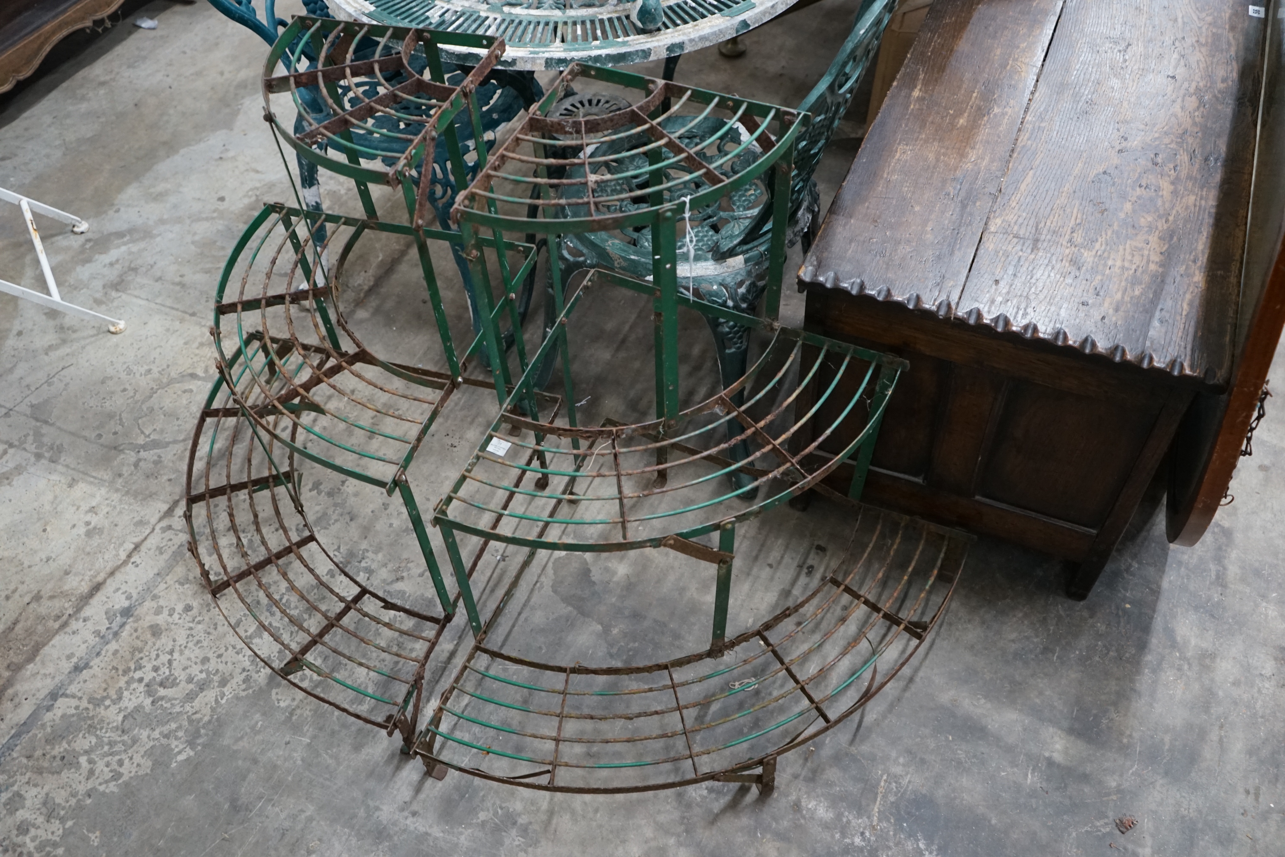 A pair of painted metal three tier corner garden pot stands, height 75cm